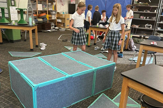 2 girls in STEM class building life sized magnetic tiles